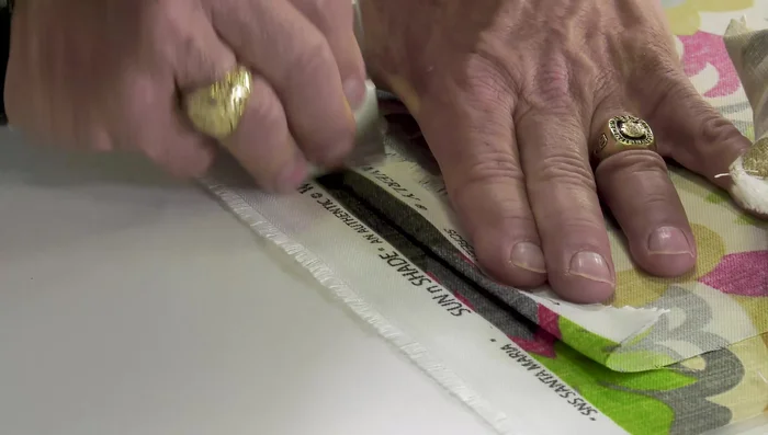 Create crease lines: Using a patterning ruler (or other hard object), firmly crease the fabric along the pinned edges, ensuring the pattern aligns perfectly. Use your thumb and forefinger to hold the fabric securely and prevent stretching. Mark crease lines with a washable fabric marker on the wrong side of the fabric.