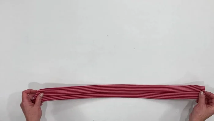 Bring the seam to the center, cross it over, and make a loose knot.