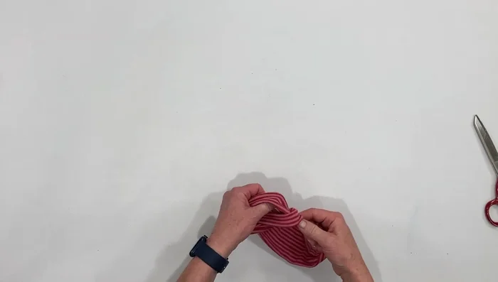 Bring the knot over the top of the seam and hide it.