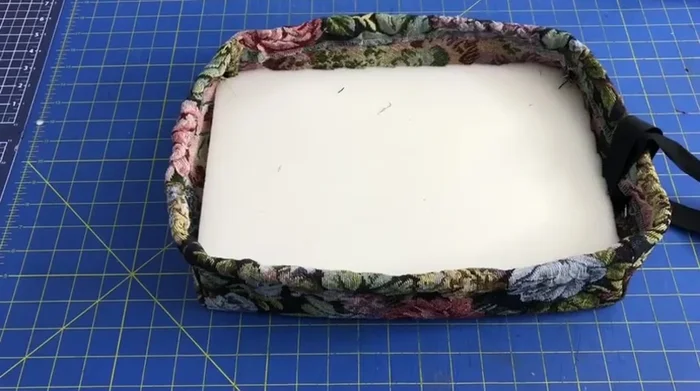 Add foam and non-skid liner inside the cover, insert the stool, tighten the drawstring, and tie a bow.