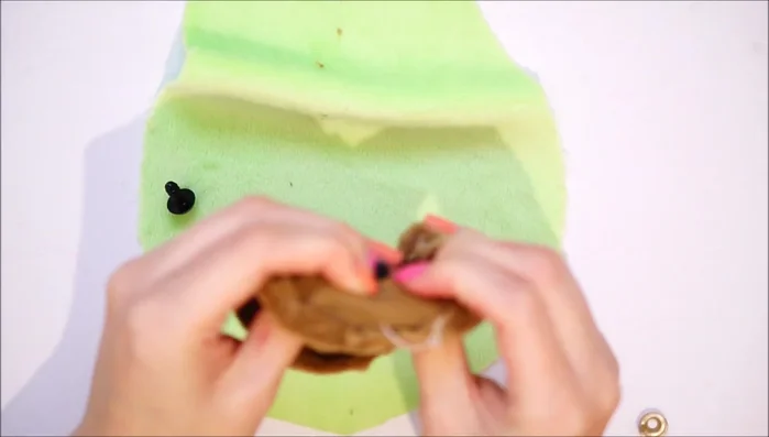Attach the pit to the lighter green fabric using a sewing machine (or hand sewing/fabric glue). Leave a small gap at the top.