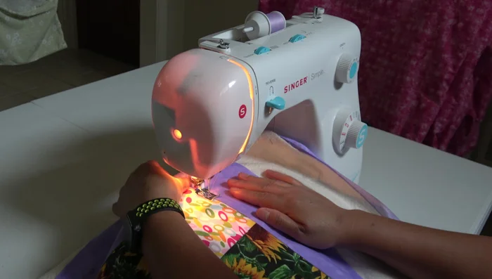 Stitch in the ditch. A walking foot is recommended.