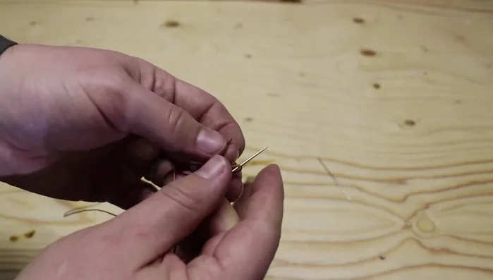 Prepare the thread and needle: Use a long piece of waxed nylon thread (although shorter pieces are recommended for efficiency) and thread it through the needle.