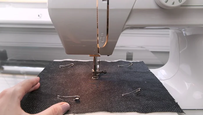 Start quilting: Begin in the center of the quilt to prevent bunching. Lower the needle, pull the threads to the back, and start sewing.