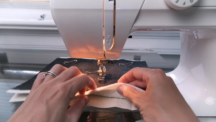 Prepare your quilt sandwich: Layer your backing fabric, batting, and quilt top. Use basting pins to secure the layers and keep them smooth.