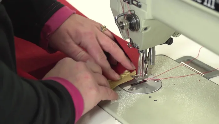 Attach piping to body panel ends: Sew decorative piping to the ends of the body panel, keeping the stitch 1/2 inch from the raw edges. Cross the ends of the piping and sew over them to create a neat join.