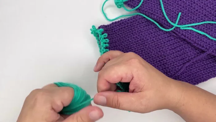 Remove the waste yarn from both ends. (The cast-on edge requires more careful removal by pulling the yarn through the initial row of stitches.)