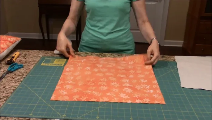 Decorate the front fabric piece. Glue or sew on your chosen embellishment (felt leaf, silk leaves, buttons, etc.).
