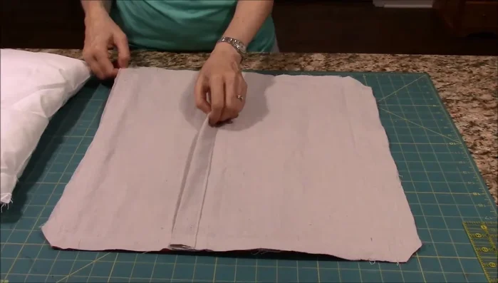 Insert the pillow form into the cover through the envelope opening in the back.