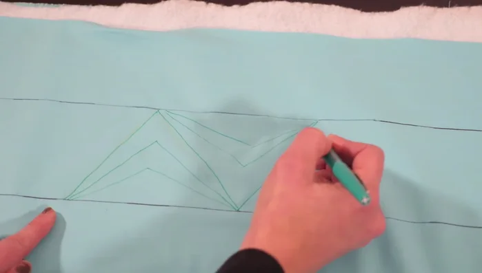 Fill in each triangle with your chosen quilting design (diamond, wedges, curved lines, etc.) ensuring you end at the starting point of the next triangle.