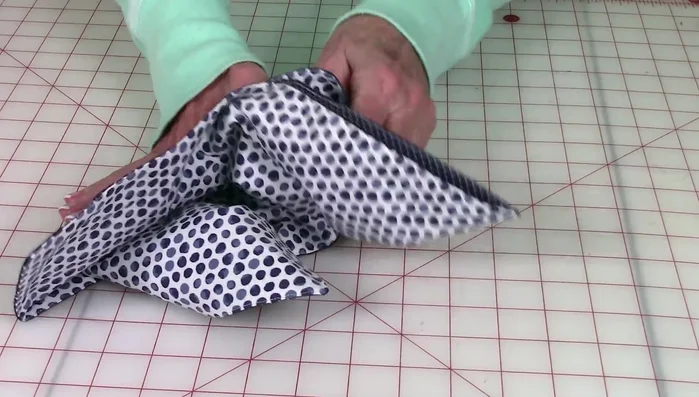 Fold the top flaps over and temporarily pin them in place. Attach buttons to each corner to hold the flaps.