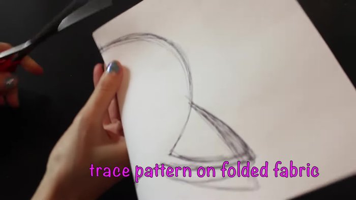 Trace your pattern onto folded fabric and cut it out symmetrically to create a cat head shape.