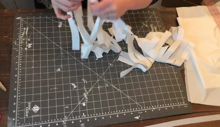 Comb through the cut strips to separate them. Unfold the piece completely, being careful not to pull too hard.