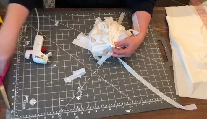 Cut about three or four inches from the three-quarter-inch piece saved earlier. Wrap this around the bottom of the loop and secure with glue. Do not pull too tightly.