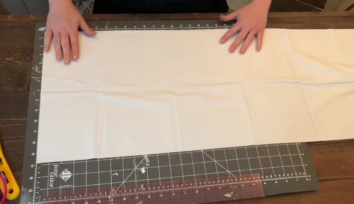 Cut the single folded edge at the bottom to create two separate pieces.