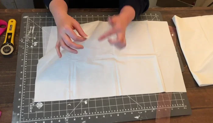 Cut the single folded edge at the bottom to create two separate pieces.
