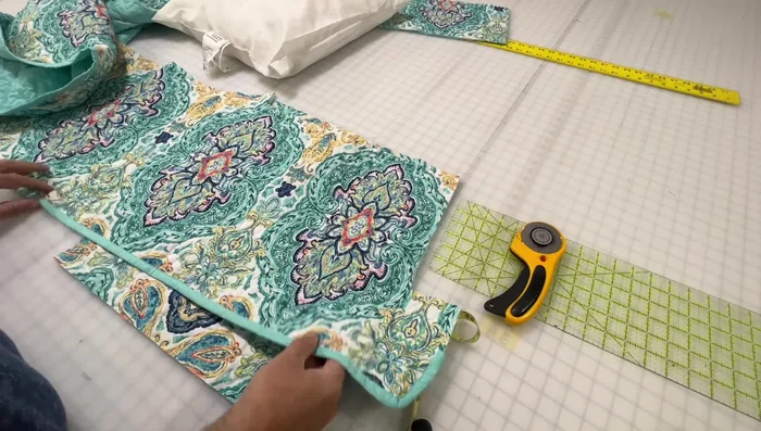 Cut envelope closure pieces: Cut two pie-shaped pieces from the quilt to create the envelope closure. Ensure the designs align when folded.