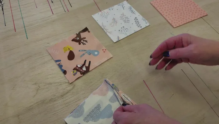 Lay out charm squares: Arrange the 5-inch charm squares in a pleasing arrangement, considering color and pattern placement. Aim for a balanced look with a dark/light alternation.