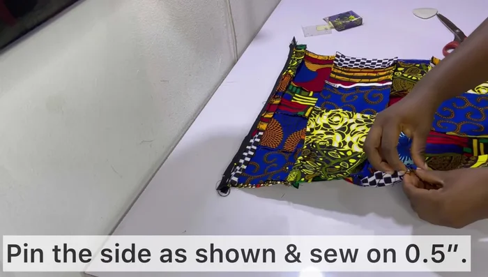 Pin and sew the sides of the pillow cover together, leaving the bottom and one side open. Sew carefully around the zipper.