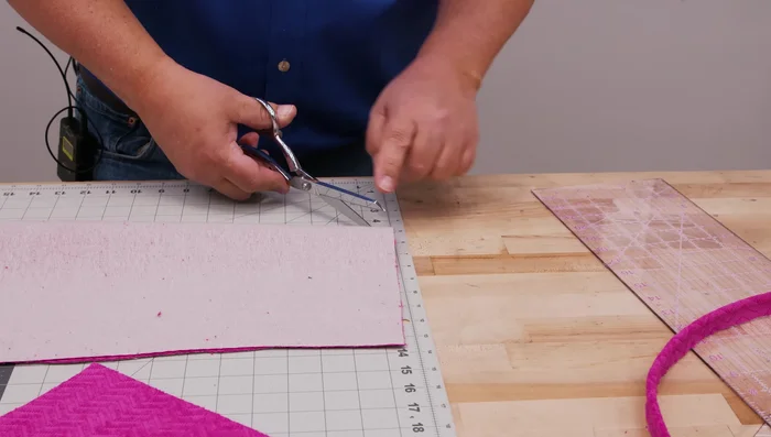 Attach piping to one chair pad piece, using a cording foot or standard foot with cording tunnel. Make small relief notches at corners for a smoother finish. 