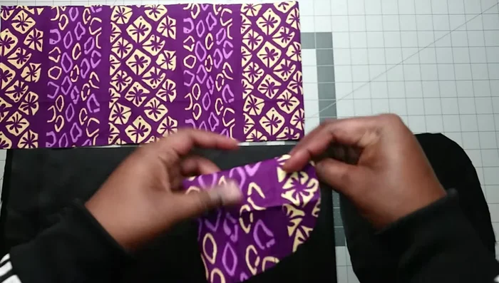 Shape the fabric: Fold the rectangle in half and shape the edges to create an oval shape.