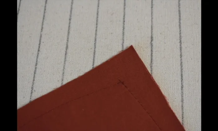 Stitch slightly beyond the pivot point of your tapered corners (1-2 stitches) on both sides to create a sharp, clean corner after turning the pillow right side out.