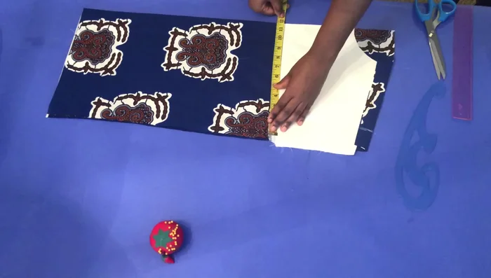 Cut the neckline: Divide the chest measurement by four, add seam allowance (e.g., 10.5 inches), and draw a straight line to the bottom before cutting.