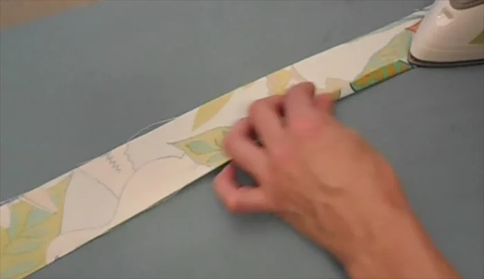 Fold the long edges of the 2 1/4in strips under less than 1/2 inch, press with an iron, then fold the sides together and iron.