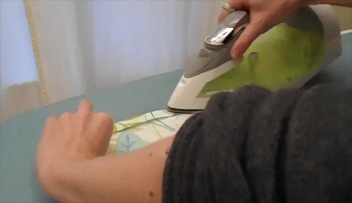 Measure 2 inches from the bottom seam of the back panel and pin a panel in place. Sew along the bottom 1/2 inch from the edge to secure.