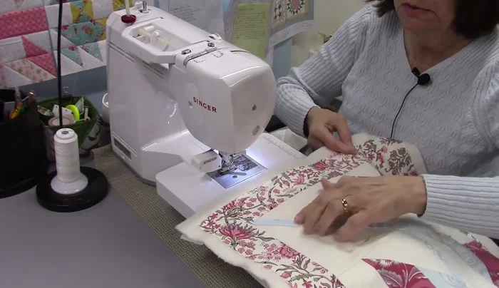 Quilt the quilt block: Quilt the quilt block using straight lines, creating a square-in-a-square pattern. Remove pins as you go and quilt from the back to easily remove pins.