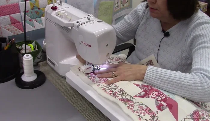 Quilt the quilt block: Quilt the quilt block using straight lines, creating a square-in-a-square pattern. Remove pins as you go and quilt from the back to easily remove pins.