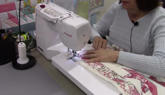 Quilt the quilt block: Quilt the quilt block using straight lines, creating a square-in-a-square pattern. Remove pins as you go and quilt from the back to easily remove pins.