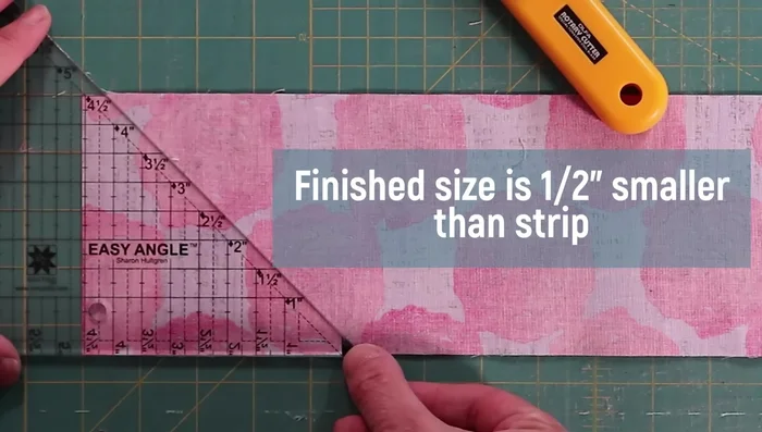 Place fabric strip against ruler, align with desired HST height.