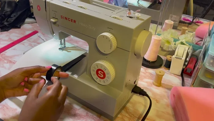 Create a sewing guide on your machine using tape. Pleat the tulle strips by hand. Sew the pleated tulle strips together, creating one continuous strip.