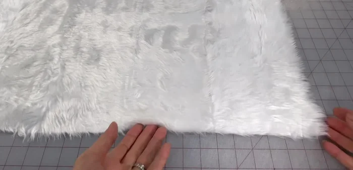 Cut main fabric 4 inches by 20 inches. Cut faux fur 2 inches by 20 inches (avoid cutting through both layers of fur to minimize shedding).