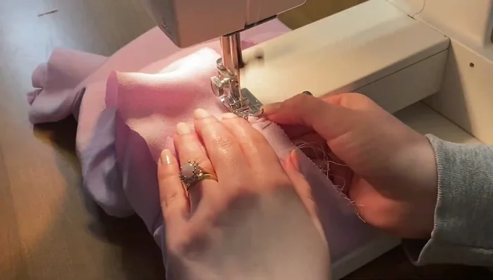 Topstitch neck facing.