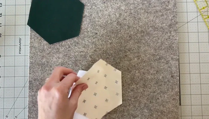 Iron the fusible fleece to the back of the top fabric. Follow manufacturer's instructions (usually involves placing fabric wrong side up, adhesive side of fleece down, pressing with a hot iron for 10-15 seconds).