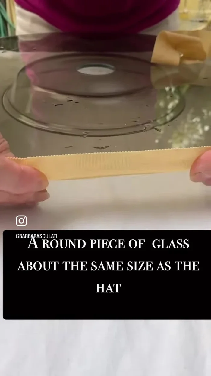 Stretch the wet ribbon over the glass disc, using plastic clothes pins to secure and shape it to the curve of the hat.