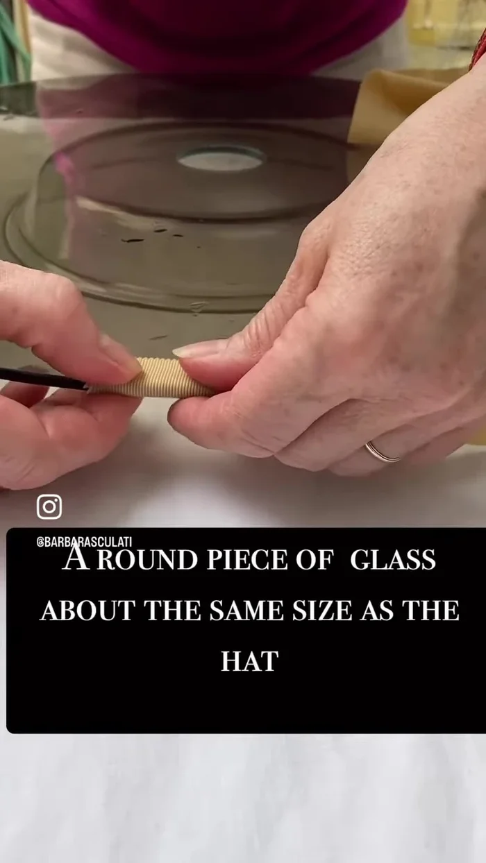 Stretch the wet ribbon over the glass disc, using plastic clothes pins to secure and shape it to the curve of the hat.