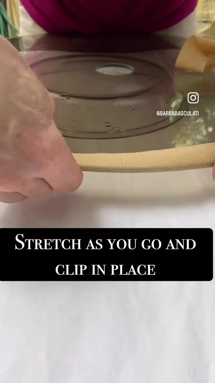 Stretch the wet ribbon over the glass disc, using plastic clothes pins to secure and shape it to the curve of the hat.