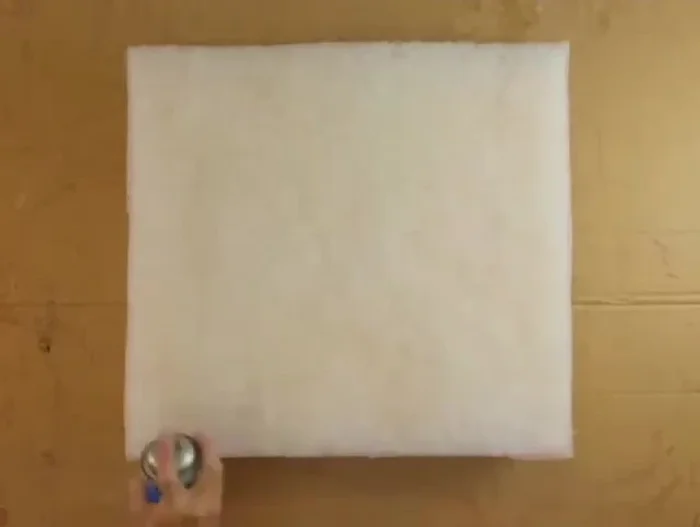 Apply a light coating of spray glue to both the batting and foam surfaces.