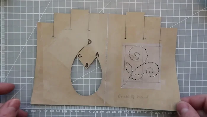 Fold the pattern to ensure symmetry and draw the back of the hand.