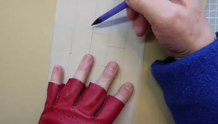 Fold the pattern to ensure symmetry and draw the back of the hand.