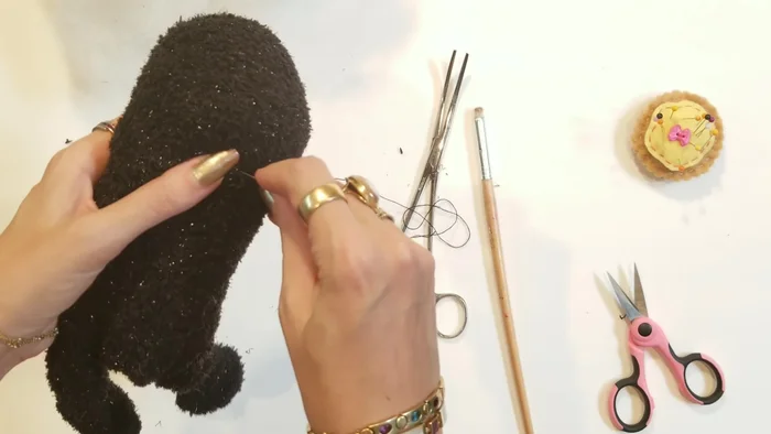 Create the neck: Using a running stitch, sew around the neck area of the sock to define the head and neck.