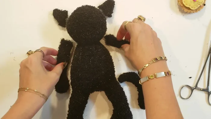 Attach limbs, tail, and ears: Pin the limbs, tail, and ears into place. Whip stitch to secure them.
