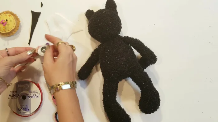 Add facial features: Use felt or googly eyes to create the cat's face. Attach with glue or stitching.