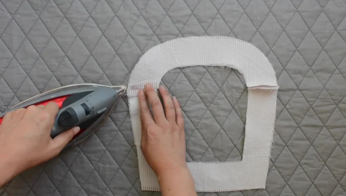 Press outer edge of facing under 1/4 inch, using the previous stitch as a guide.