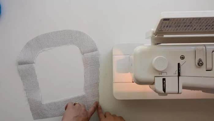 Press outer edge of facing under 1/4 inch, using the previous stitch as a guide.