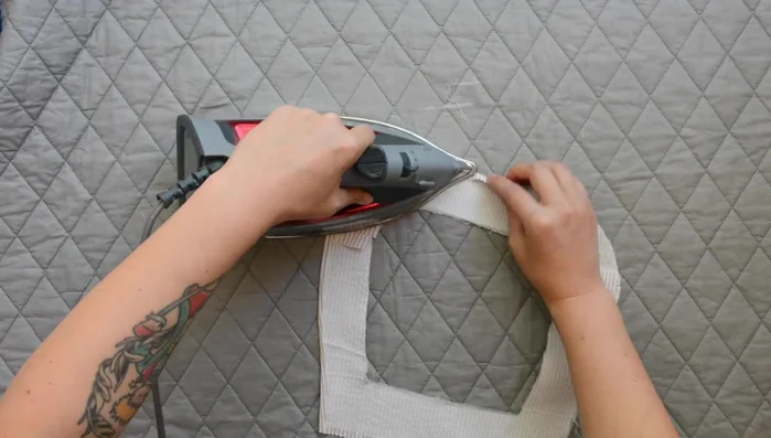 Press outer edge of facing under 1/4 inch, using the previous stitch as a guide.