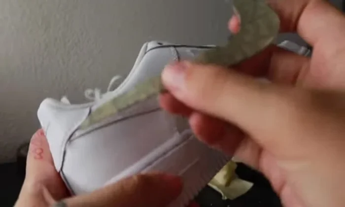 Apply glue to the shoe and carefully place fabric over the taped area. Press firmly to ensure adhesion. For thicker fabrics, remove the Nike check mark before applying fabric.